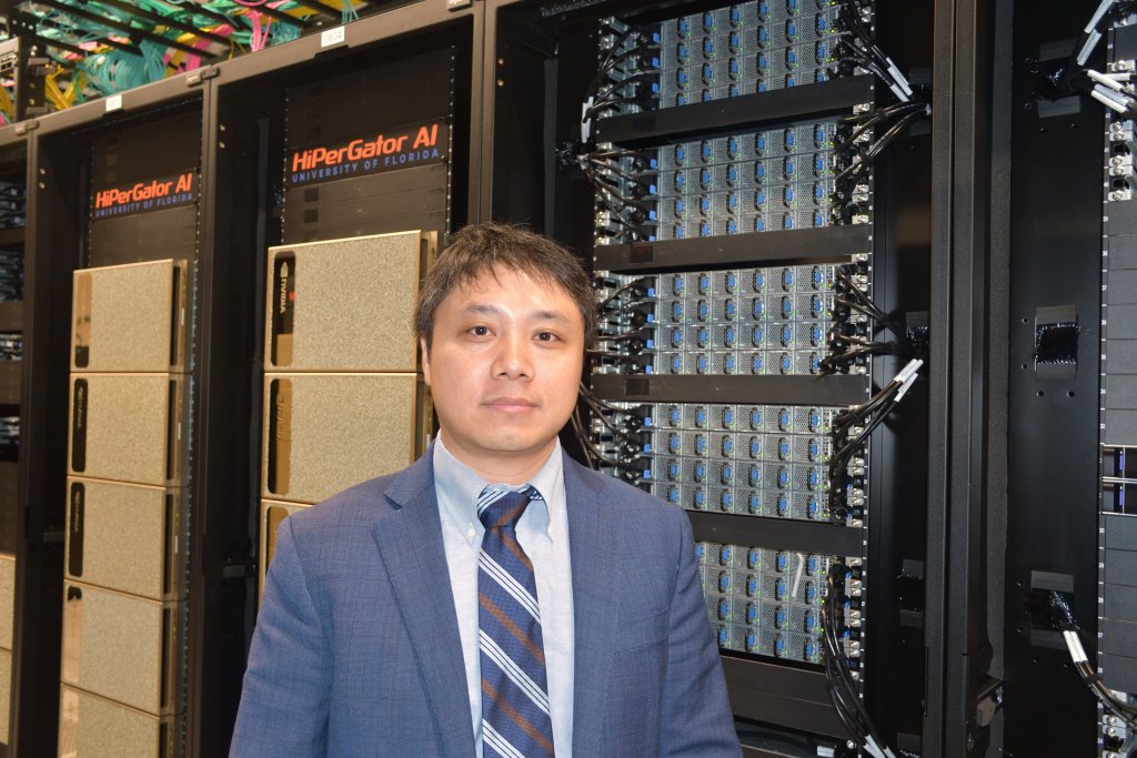 Yonghui Wu, Ph.D., stands beside the HiPerGator supercomputer.